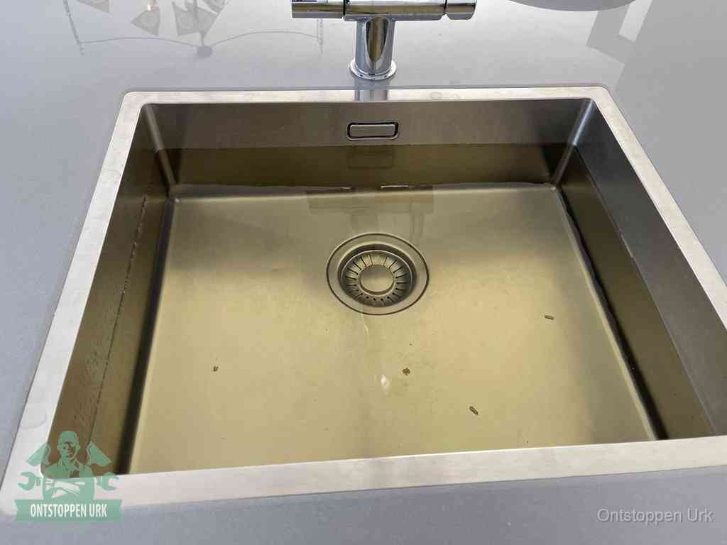 Een RVS spoelbak met stilstaand water dat niet wegloopt, een van de eerste signalen van een beginnende verstopping in Urk
