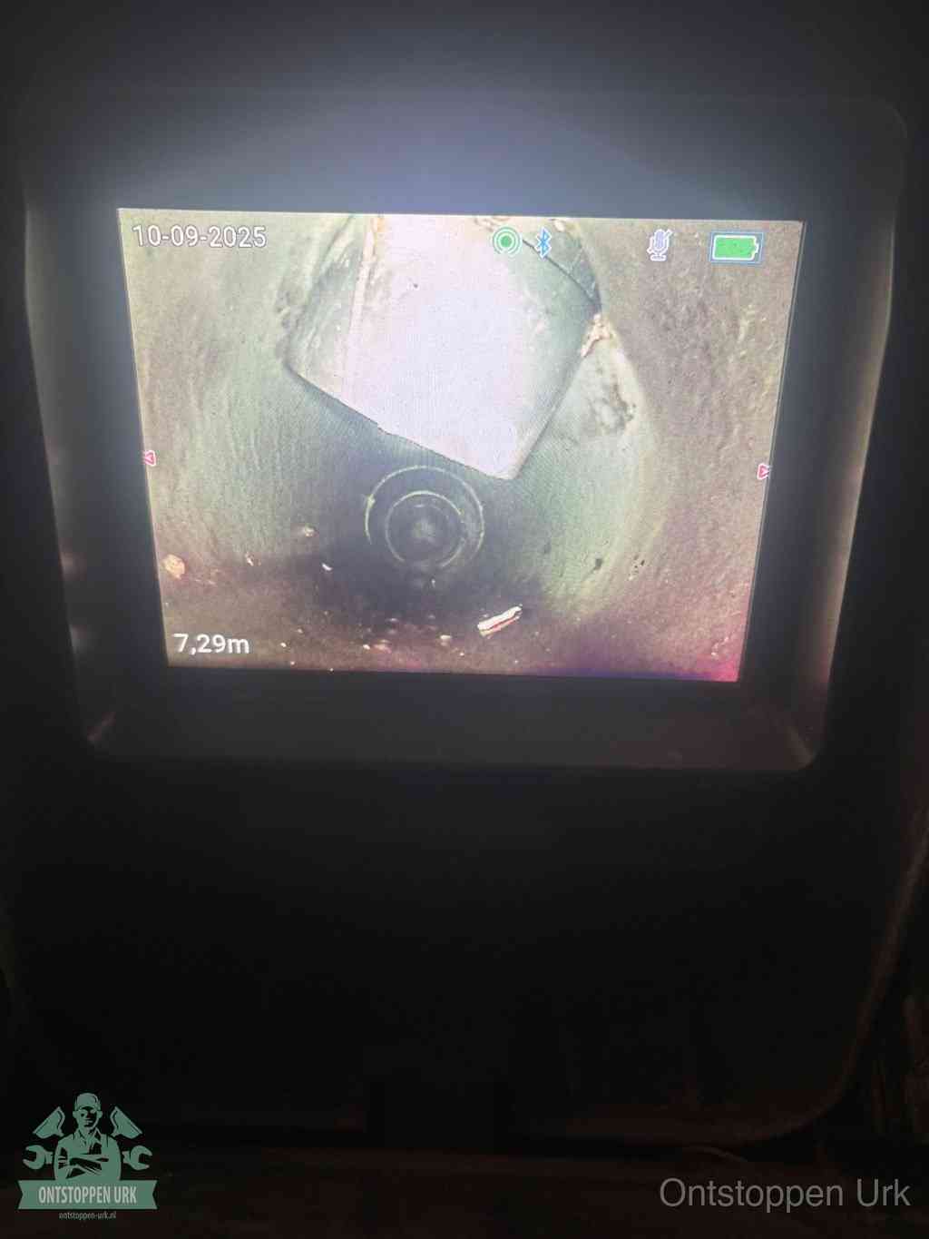 Het scherm van een rioolinspectiecamera toont de binnenkant van de leiding, eerst vaststellen waar de verstopping zit in Urk