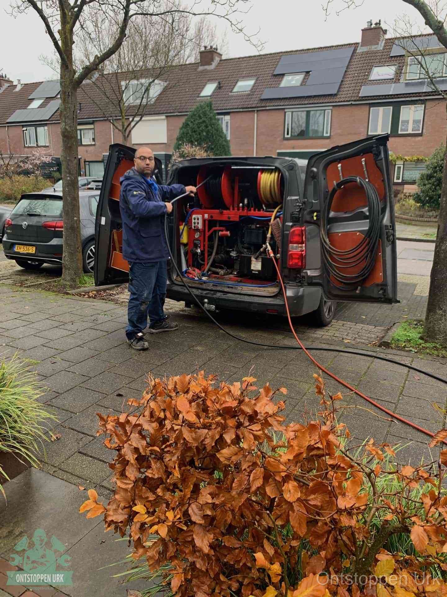 Een monteur staat bij zijn open bestelbus met hogedruk-rioolreinigingsapparatuur, klaar om binnen 30 minuten uit te rukken voor een spoedverstopping in Urk