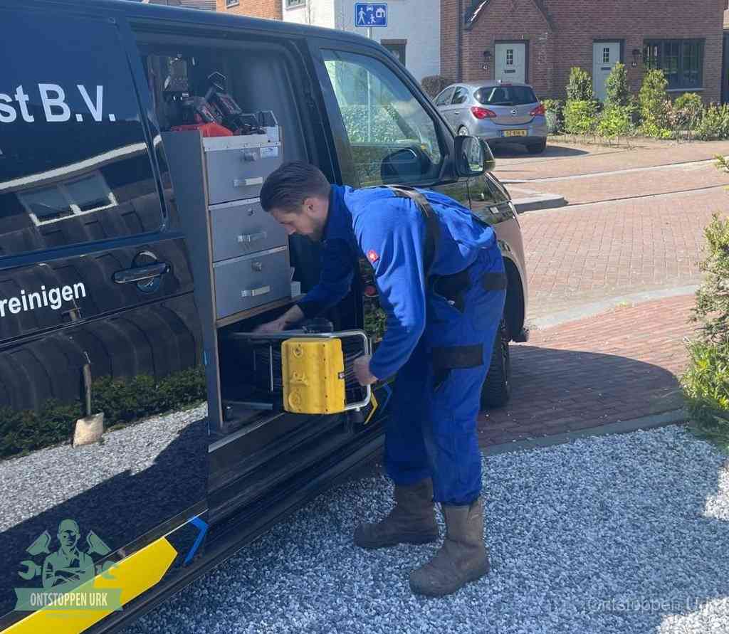 Een monteur pakt gereedschap uit de bedrijfsbus, het moment om een professionele ontstoppingsdienst in te schakelen in Urk
